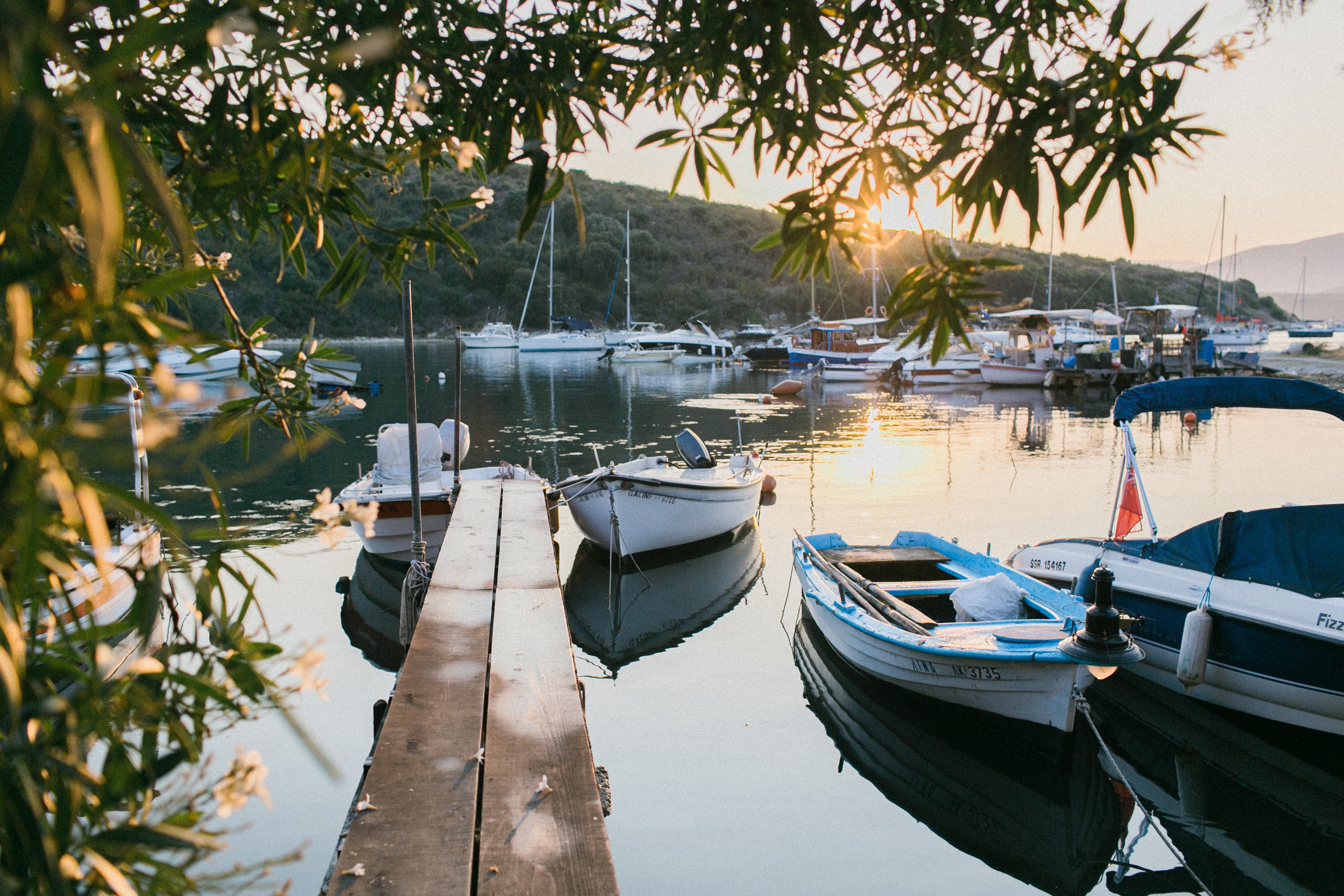 A picturesque sunset casts a warm glow over boats docked at the harbor, embodying Dockshare's ethos of respectful sharing.