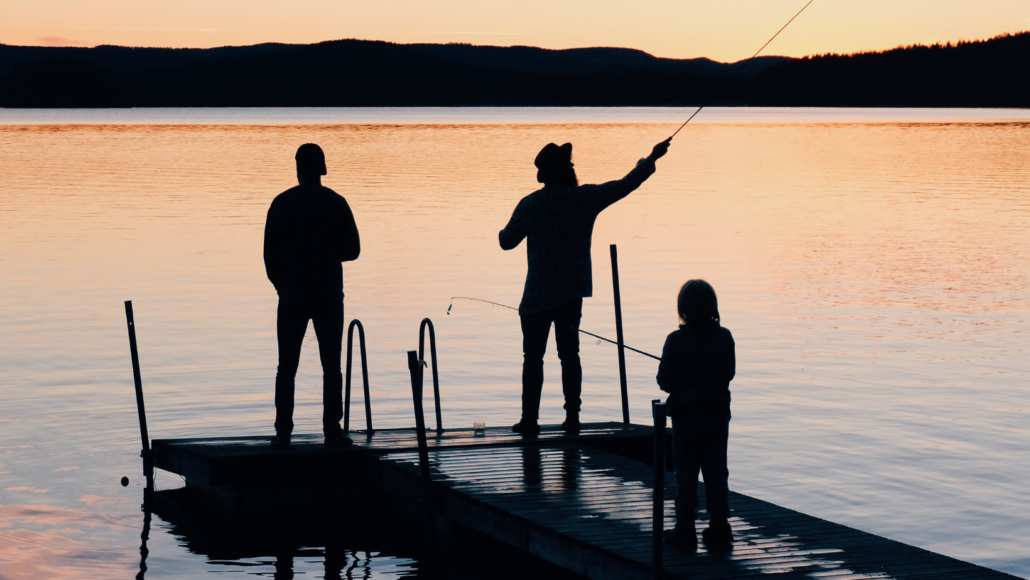 A family fishes from a dock at dusk becasue they have access to the water
