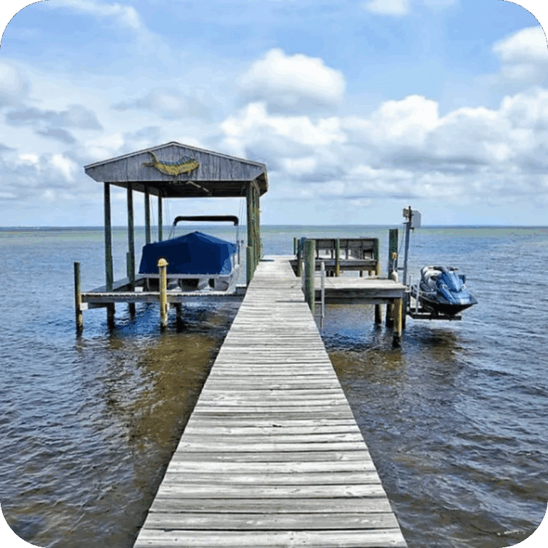 a dock extend out into a large body of water with a covered boat lift on one side and a jetski lift on the other