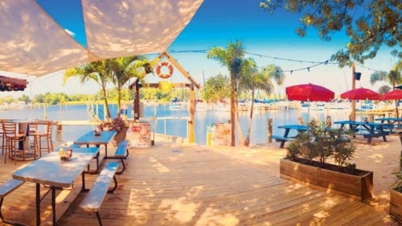 Dining on the Water - How to Make it Easy A scenic restaurant deck with tables and umbrellas, offering a great dining experience on the water, according to Dockshare's advice.