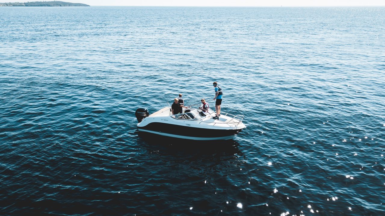 A couple stands at the rear of a boat, embracing the boating lifestyle, a testament to Dockshare's rich maritime heritage.